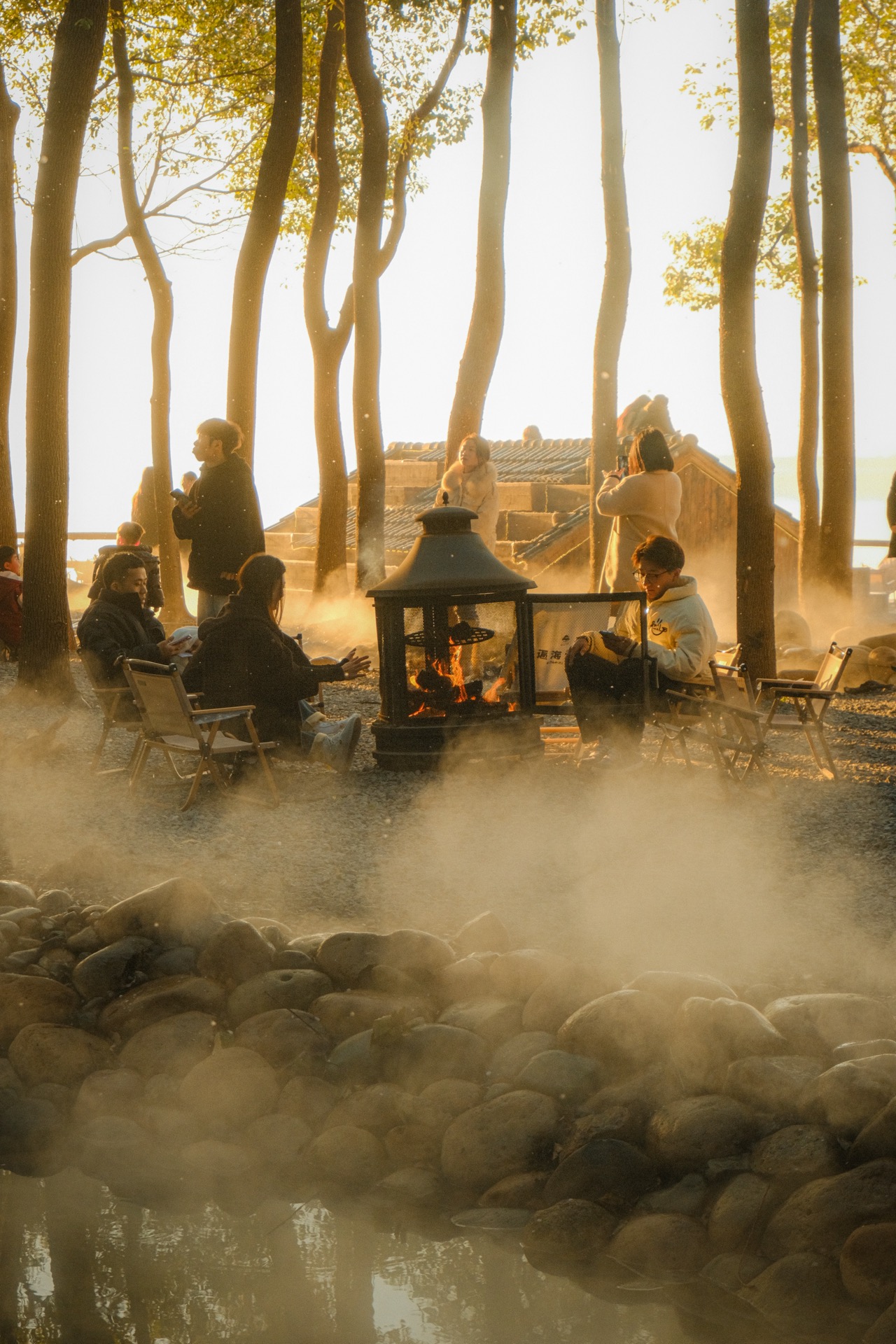 People gathered around a fire in golden misty light